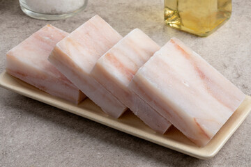 Dish with frozen pollock fish fillets to thaw as an ingredient for cooking 