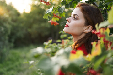 Naklejka premium Woman red dress green leaves nature summer