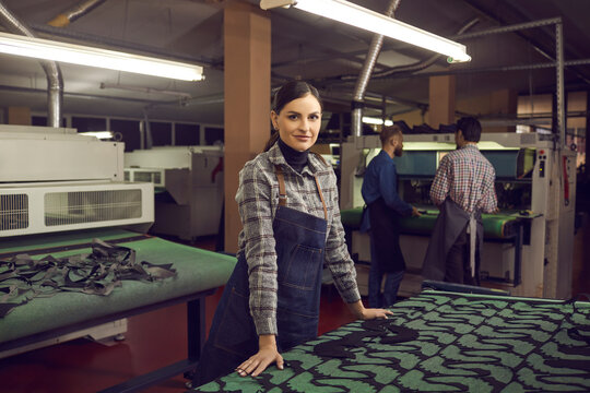 Work Process Of An Employee At A Shoe Factory. Portrait Of A Female Shoe Factory Worker Standing At A Desk With Patterns For Future Shoes. Footwear And Apparel Manufacturing Industry Concept.