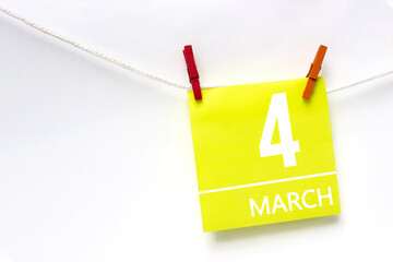 March 4th. Day 4 of month, Calendar date. Paper cards with calendar day hanging rope with clothespins on white background. Spring month, day of the year concept.