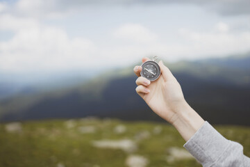 Traveler hand holds a compass on the beautiful Carpathian mountains during vacation. Horizontal banner with place for text. Technology interenet and travel adventure concept.