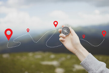 Mountain progression path. Traveler hand holds a compass in the mountains during vacation. Horizontal banner with place for text © Shi 
