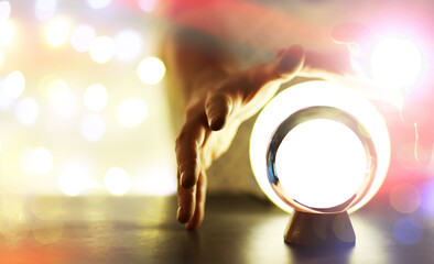 Crystal Ball on the table with bokeh, lights behind. Glass ball with colorful bokeh light, prediction concept.