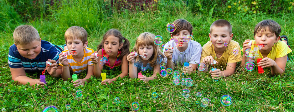 Children blow bubbles in the street. Selective focus.