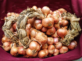 A bunch of shallots placed on a cloth bag.