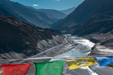 A confluence of rivers with religious flags in the foreground.
