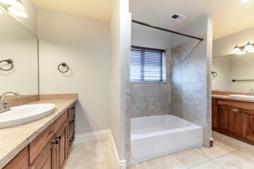 Fototapeta na wymiar Master bathroom with bathtub in the middle of two vanities