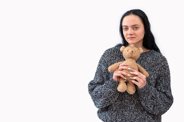 young woman holding teddy bear, isolated on white background