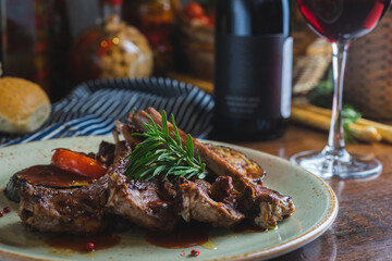 Fried ribs with a glass of red wine on a table in a restaurant close-up