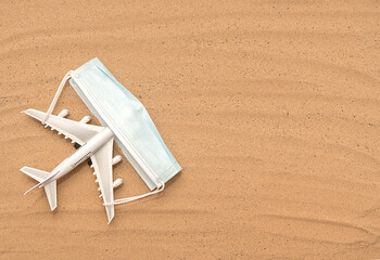 Passenger white plane on the sand with a mask.