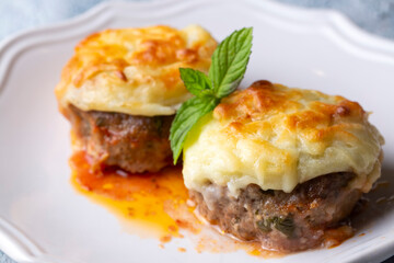 Turkish Food Hasanpasa Kofte - Kofta with Puree - Meatball with Bechamel Sauce and Green Peas. Traditional Food.