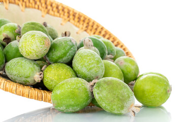Several ripe sweet feijoa fruits with a ceramic plate, close-up, isolated on white.