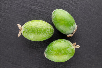Three fragrant sweet feijoa fruits  on a slate stone, close-up, top view.