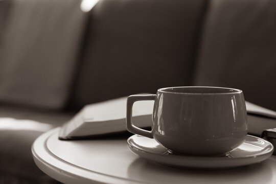 cup of coffee on table by sofa with open bible and copy space