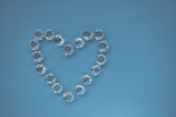 The heart is lined with transparent beads. Background of transparent crystals. Flat picture. Photographed from above. selective focus