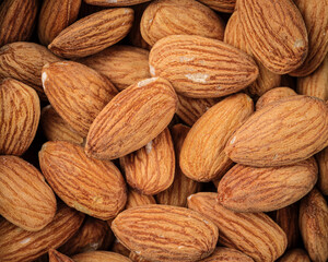 Closeup on scattered almond nuts background texture