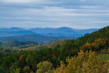 Fototapeta na wymiar Panorama boscoso e montagnoso in una giornata autunnale