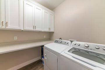 Interior of a laundry room with top cabinets and countertop