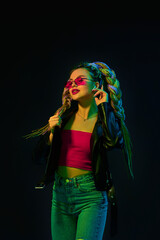 young woman with dreadlocks in red sunglasses dancing