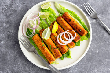Indian Chicken Seekh Kebab with Condiments on Dark Background Directly Above Photo
