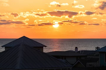 Fotobehang High angle aerial view on colorful yellow sunset ocean landscape horizon of Gulf of Mexico in Seaside, Florida and buildings houses cityscape © Kristina Blokhin