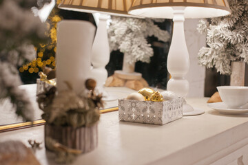 christmas decorations on mantelpiece at home in white gold colors