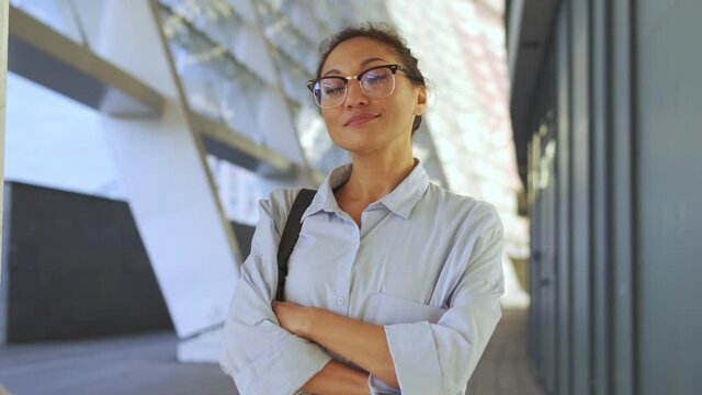 Self-confident Serious Biracial Woman In Casual Shirt And Eyeglasses Crossing Hands On Chest And Looking At Camera, Set To Vin In Any Endeavors, Ready To Fight For Rights And Freedom Standing Outdoor