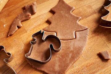 Cutting out pastry shapes for homemade gingerbread Christmas cookies