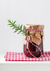Homemade sweet organic plum jam in a jar decorated with grunge paper and wax seal. Christmas and...