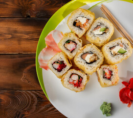 sushi with pickled ginger and wasabi on a plate on the background of a wooden table made of boards. top view.