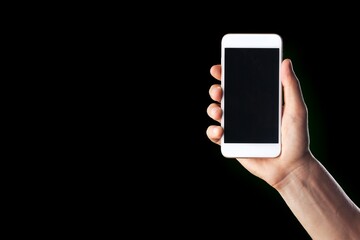 Male hand holding a smartphone with blank screen.