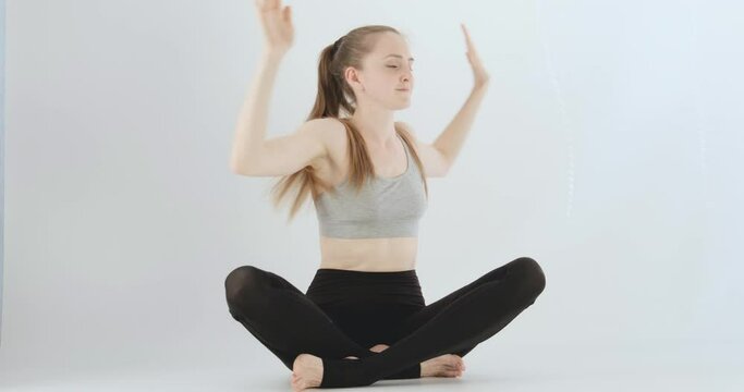 Girl does the exercises. Young woman does an exercise for posture and back health. Warm-up. White background