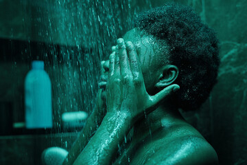 African young woman with black curly hair having a shower in the bathroom