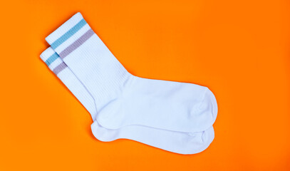 Pair of white cotton socks on bright background