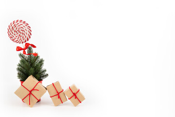 Gift box made of kraft paper with a red ribbon of a small Christmas tree on a white background for Christmas or celebration