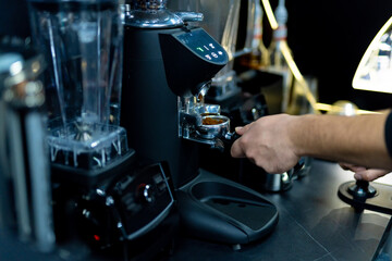 Young coffeemaker making espresso in restaurant. Barista making coffee with machine.