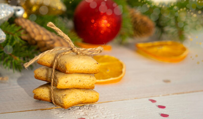 Ginger cookies, spruce branches and Christmas balls, on a white wooden background