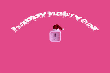 Happy New Year message with a pink clock showing midnight. A watch decorated with Santa's hat. 