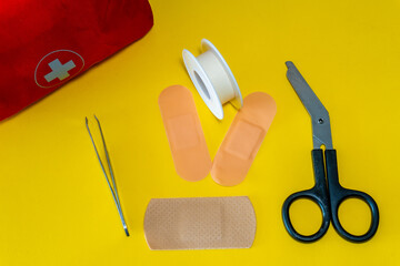 Band-aids, tape, tweezers and scissors from a first aid kit.