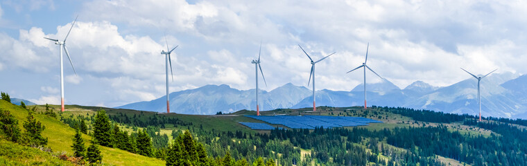green energy, solar panels and wind power station on mountain