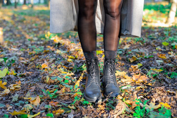 Legs of a girl in boots on an autumn walk.