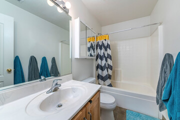 Interior of a small bathroom with gray and blue towels hanging on the wall