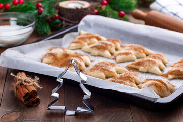 Ready to bake Christmas tree shaped puff pastry cookies with sugar and cinnamon, cookie cutter
