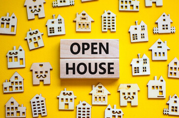 Open house symbol. Concept words 'Open house' on wooden blocks near miniature houses. Beautiful yellow background, copy space. Business and open house concept.