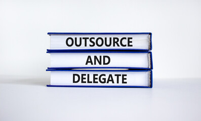 Outsource and delegate symbol. Concept words 'Outsource and delegate' on books. Beautiful white background. Business, outsource and delegate concept, copy space.