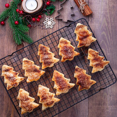 Christmas puff pastry cookies with sugar and cinnamon on a cooling rack, square, top view
