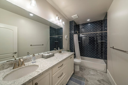 Master bathroom with double vanity sink and shower tub with black subway tiles surround