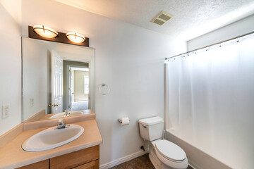 Small bathroom interior with white wall and brown vanity sink and countertop