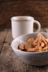 Dried apples in a bowl against a dark old wooden background