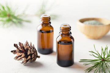 Pine essential oil in small glass bottles. Soft focus.
